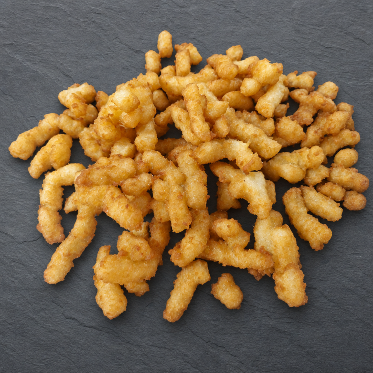 The Crumble — crispy golden crumble on dark anthracite background